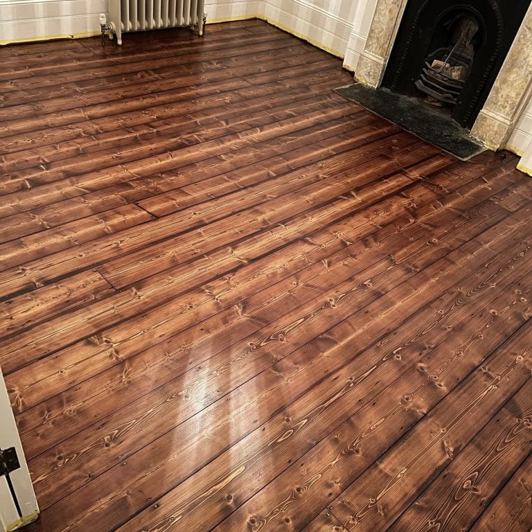 A pine floor restoration with a dark stain and satin lacquer.